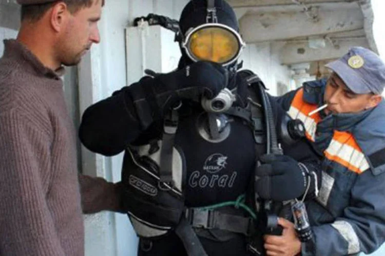 Um mergulhador da equipe de resgate se prepara para entrar no rio Volga à procura de mais corpos: eles ainda precisam inspecionar mais de 50% da cobertura do navio (AFP)