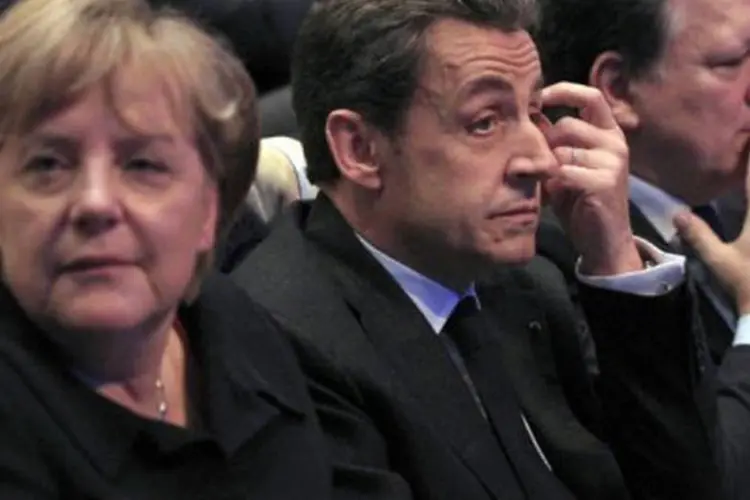 Angela Merkel, Nicolas Sarkozy e o presidente da Comissão Europeia, José Manuel Barroso: para a chanceler alemã, o acordo permitirá ao euro restaurar sua "credibilidade" (Jean-Paul Pelissier/AFP)