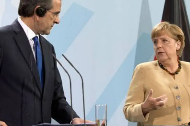 
	Samaras e Merkel: a chanceler alem&atilde; disse que o cumprimento dos compromissos recupera a confian&ccedil;a do mercado e diminui os impactos da crise
 (David Gannon/AFP)