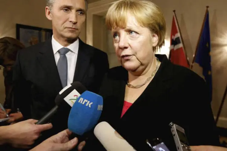 
	Merkel &eacute; entrevistada ao lado do premier da Noruega, Jens Stoltenberg: &quot;Creio que a comunidade internacional compreendeu que vamos defender o euro&quot;, disse Merkel
 (AFP/Lise Aserud)