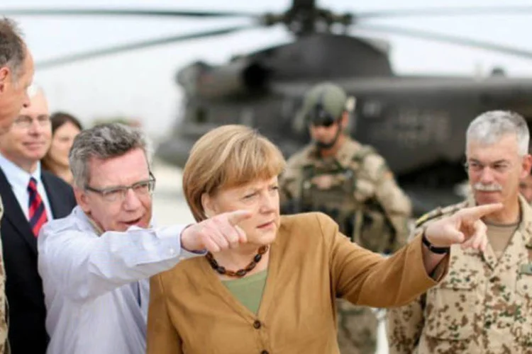 
	O ministro da Defesa da Alemanha, Thomas de Maiziere, e a chanceler Angela Merkel em Kunduz, no Afeganist&atilde;o: esta &eacute; a quinta visita de Merkel ao Afeganist&atilde;o desde 2007
 (AFP / Kay Nietfeld)