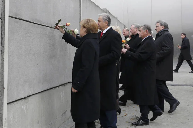 
	Prefeito de Berlim, Klaus Wowereit, a chanceler alem&atilde;, Angela Merkel, e outras autoridades colocam flores em vest&iacute;gios do Muro de Berlim
 (Reuters/Fabrizio Bensch)