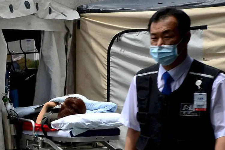 
	M&eacute;dico em frente &agrave; paciente em quarentena na Coreia do Sul: um homem de 62 anos morreu neste domingo
 (REUTERS/Park Jung-ho/News)