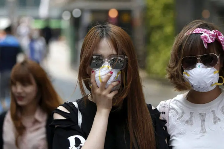 
	Turistas usam m&aacute;scaras para evitar contra&ccedil;&atilde;o da MERS, na Coreia do Sul: O n&uacute;mero de infectados subiu para 126
 (REUTERS/Kim Hong-Ji)