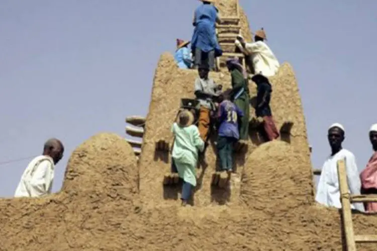 Foto de 2006 mostra residentes locais restaurando a Mesquita de Djingareyber, no Mali (Issouf Sanogo/AFP)