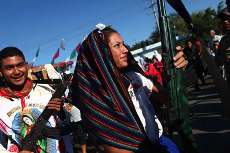 Cidadãos seguram armas durante marcha em comemoração ao primeiro aniversário de fundação da comunidade de autodefesa de Michoacan, no México (REUTERS/Edgard Garrido)