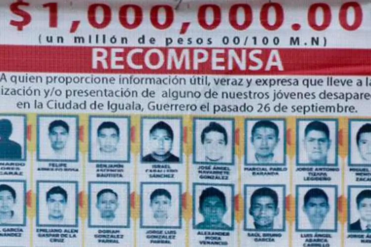 Cartaz com as fotos dos 43 estudantes desaparecidos e anúncio de recompensas é visto em Cocula, estado de Guerrero, em 20 de outubro de 2014 (RONALDO SCHEMIDT/AFP)