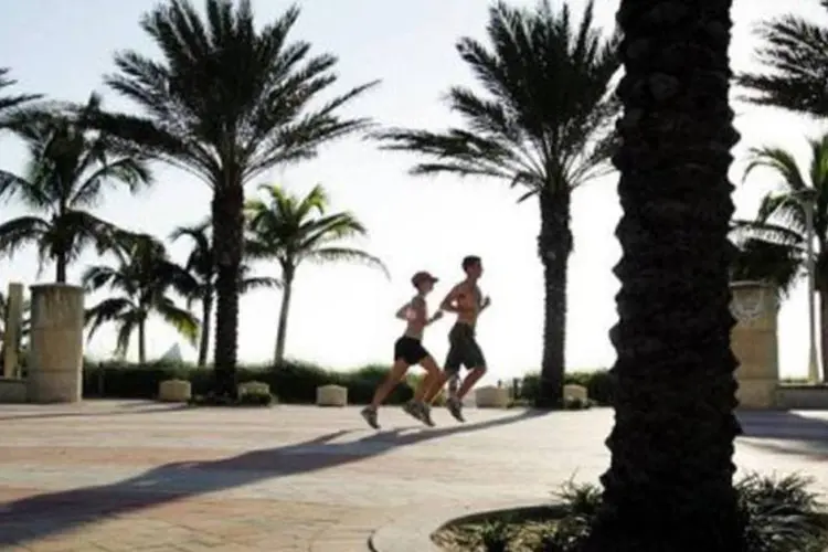 Duas pessoas correndo em praia de Miami (AFP/Arquivo / Roberto Schmidt)