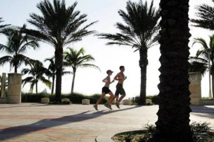 Duas pessoas correndo em praia de Miami (AFP/Arquivo / Roberto Schmidt)