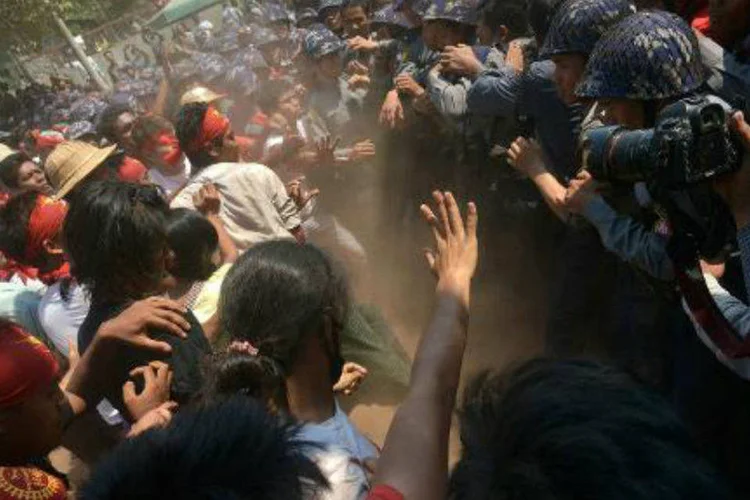 Estudantes e policiais entram em confronto durante passeata em Mianmar; jornalistas presenciaram o momento em que a polícia reprimiu os manifestantes a pauladas e os colocou em caminhões (AFP/ Phyo Hein Kyaw)
