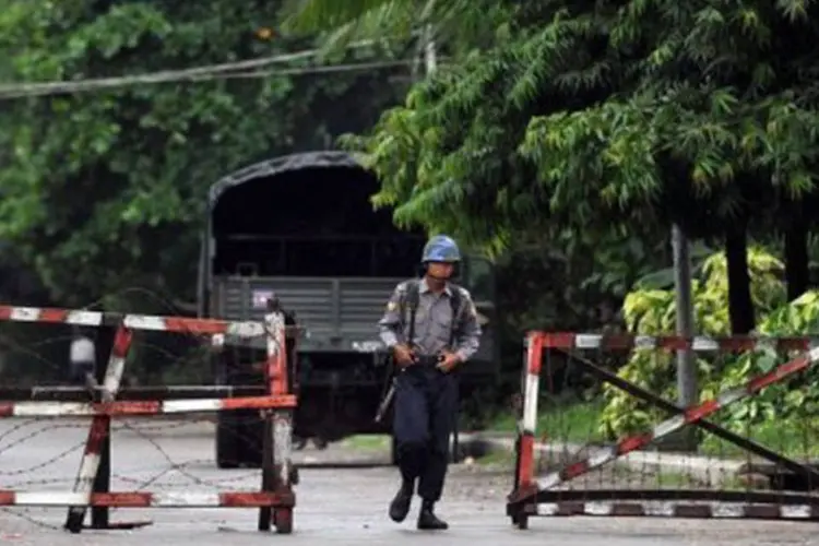 Policial caminha pelas ruas de Sittwe, capital de Rakhin: o estado está em situação de emergência desde 10 de junho (AFP)