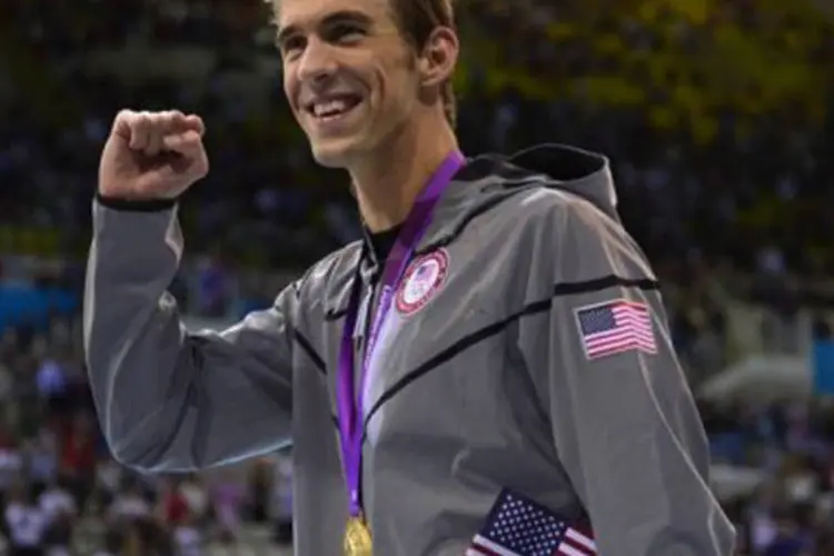 
	Michael Phelps posa com uma de suas medalhas de ouro nos Jogos de Londres, em 4 de agosto de 2012
 (Fabrice Coffrini/AFP)