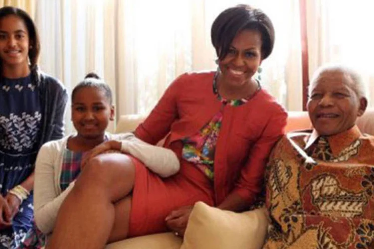 Uma sorridente Michelle Obama posa ao lado do líder Nelson Mandela; suas filhas, Malia e Sasha, também pariciparam do encontro (Debbie Yazbek/AFP)