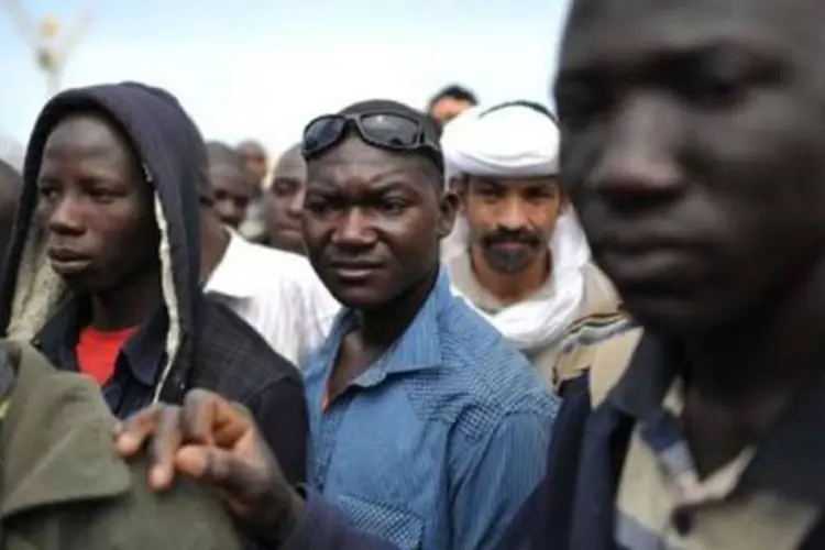 Migrantes africanos e refugiados aguardam para embarcar no porto de Misrata, na Líbia ( Christophe Simon/AFP)