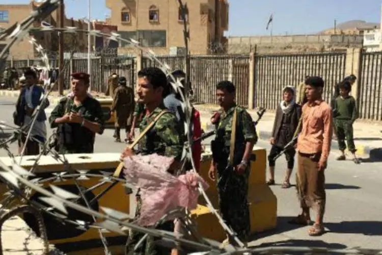 Milicianos huthi vestindo uniformes roubados do Exército posicionam-se em uma barreira em torno da residência do presidente do Iêmen (Gamal Noman/AFP)