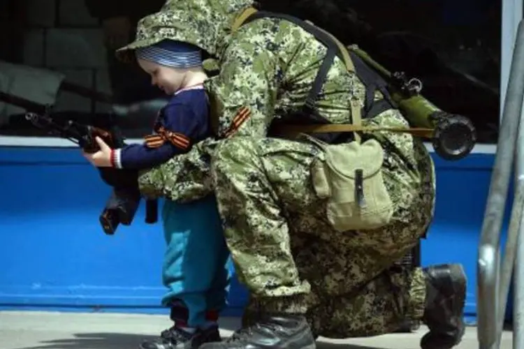 Militante pró-Rússia brinca com criança na Ucrânia: "é a volta do sistema criado em 1949", disse Serguei Riabkov, vice-ministro russo das Relações Exteriores (Vasily Maximov/AFP)