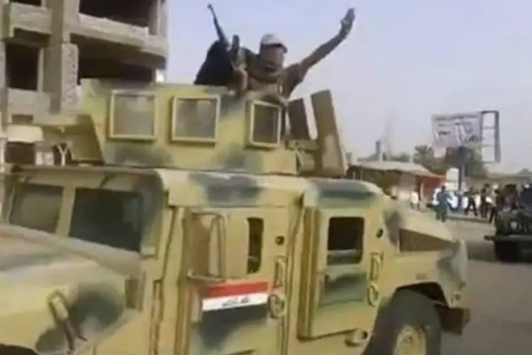 Militantes do EIIL em um blindado do Exército iraquiano, na cidade de Baiji (AFP/Arquivos)