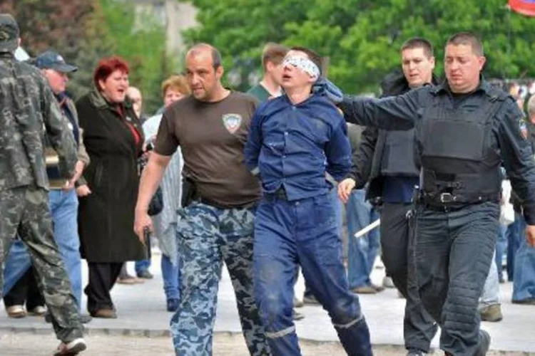 
	Militantes pr&oacute;-R&uacute;ssia retiram homem de pr&eacute;dio de Donetsk, leste da Ucr&acirc;nia
 (Genya Savilov/AFP)