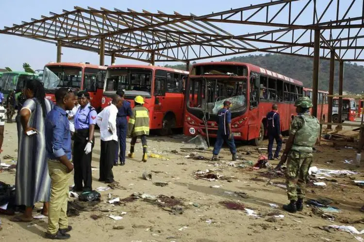 Militares montam guarda próximos a veículos danificados em local de explosão na Nigéria: algumas fontes assinalam que poderia haver até 200 mortos (Afolabi Sotunde/Reuters)