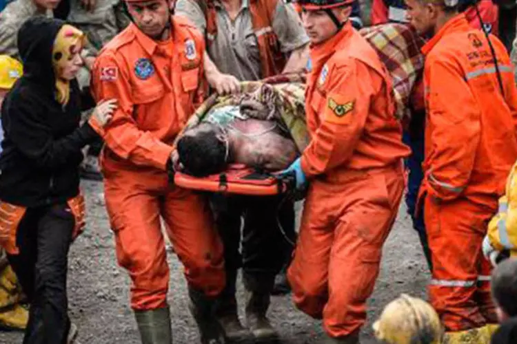 Equipes de resgate socorrem trabalhador ferido em explosão: o desespero e a revolta aumentam à medida que diminui a esperança de resgatar com vida os mineiros (Bulent Kilic/AFP)