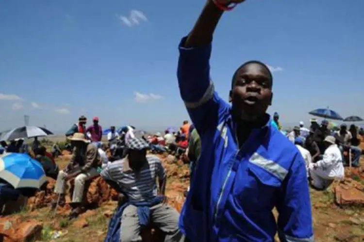 Mineiro grevista convoca outros a protestarem em 22 de outubro durante uma greve em Carletonville, na África do Sul
 (Alexander Joe/AFP)