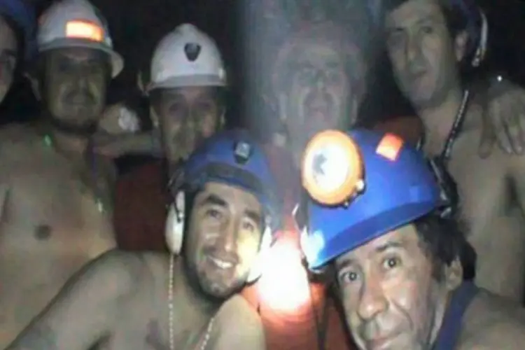Familiares e amigos dos mineiros, que fazem vigílias à luz de velas na mina de cobre e ouro localizada no deserto do Atacama (.)