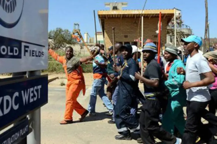 
	Grevistas da mina do grupo sul-africano Gold Fields protestam: a mina KDC East, que emprega 12.500 pessoas, est&aacute; paralisada desde o dia 14 de outubro
 (AFP)