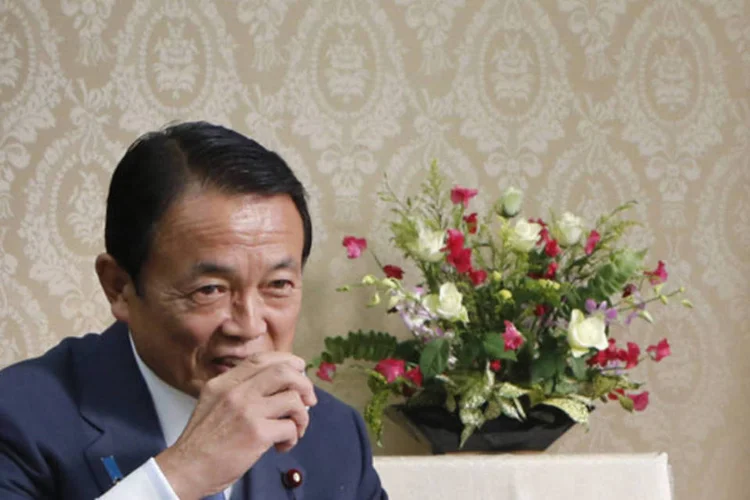 Novo ministro das Finanças do Japão, Taro Aso, toma chá verde depois de assinar documento para assumir o cargo (Yuriko Nakao/Reuters)