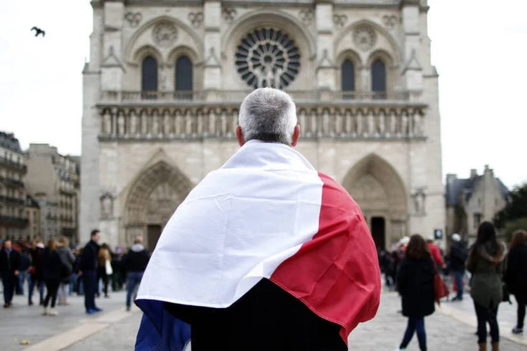 
	Minuto de sil&ecirc;ncio: centenas de pessoas sa&iacute;ram &agrave;s ruas no centro de Paris para colocar flores nos locais dos atentados
 (Charles Platiau / Reuters)