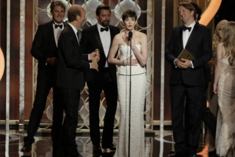 A atriz Anne Hathaway com o elenco e a equipe de "Os Miseráveis" recebe o prêmio de Melhor Filme Comédia ou Musical no palco do Globo de Ouro (EUTERS/Paul Drinkwater/NBC)