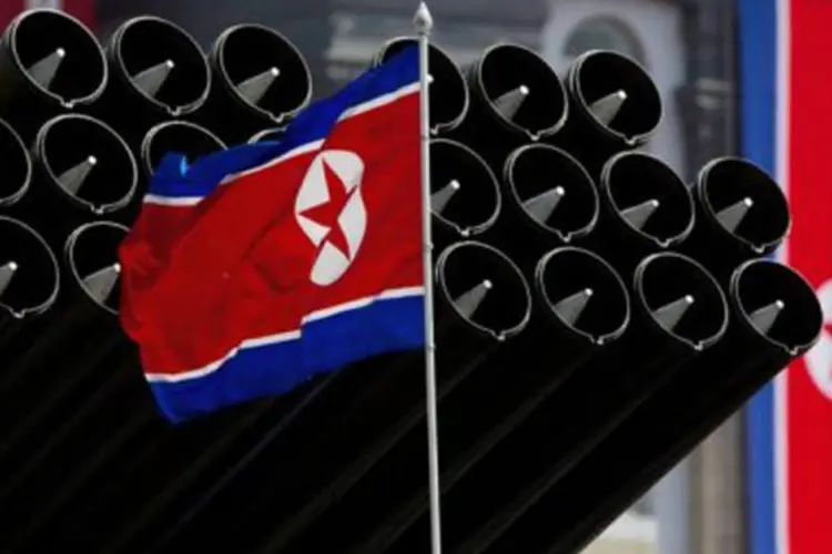 
	A bandeira norte-coreana &eacute; vista perto de m&iacute;sseis em uma parada militar: especialistas sul-coreanos acham que a advert&ecirc;ncia de Pyongyang &eacute; um &quot;blefe&quot; da Coreia do Norte
 (Ed Jones/AFP/AFP)