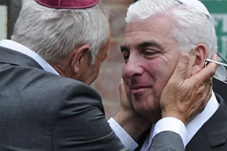 Mitch Winehouse (à direita) é consolado por um amigo durante o funeral da filha: "boa noite, meu anjo, durma bem", disse na oração fúnebre (Carl Court/AFP)