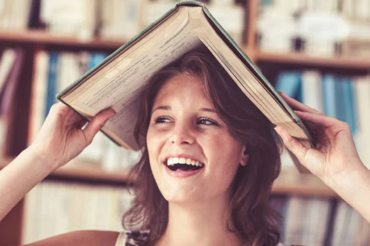moça com livro na cabeça (Thinkstock)