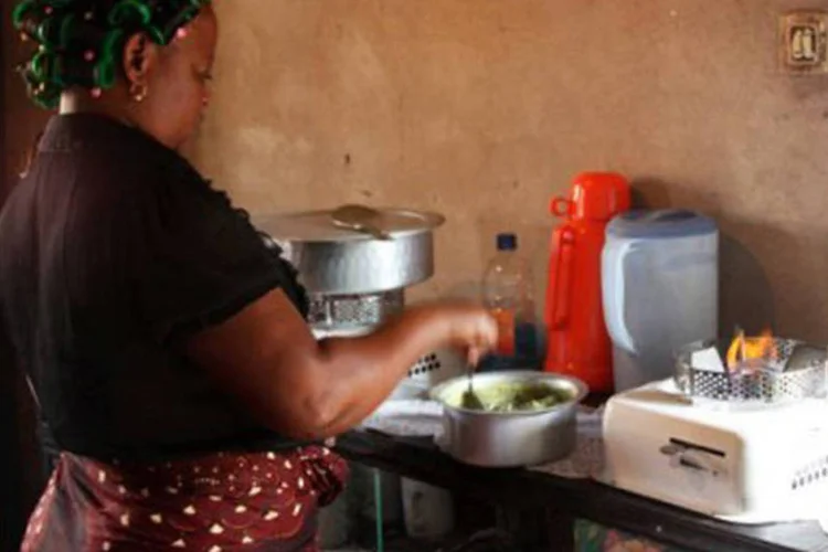Maria Douca prepara alimentos ao lado do fogareiro abastecido a etanol de mandioca: em Moçambique, 85% da energia é obtida da lenha
 (Jinty Jackson/AFP)