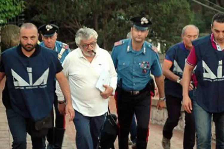 Giuseppe Mandara, no centro, acompanhado por policiais da unidade anti-Máfia: segundo investigadores, sua empresa é acusada de enganar consumidores (AFP)