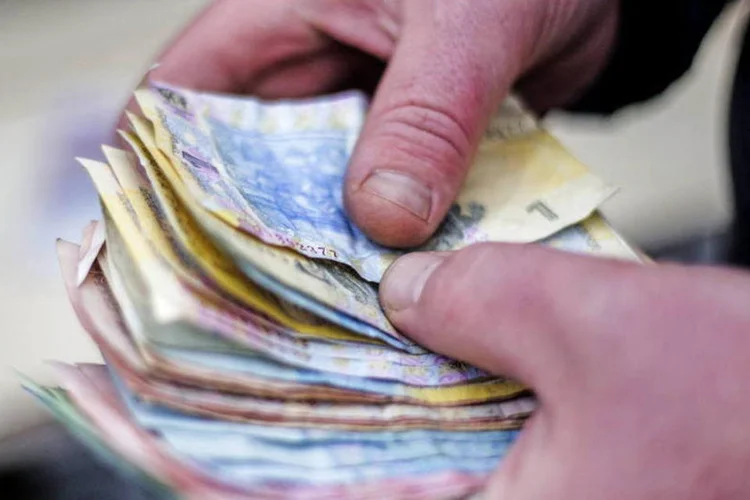 
	Comerciante segura notas de gr&iacute;vnia, a moeda ucraniana: reestrutura&ccedil;&atilde;o &eacute; uma das principais condi&ccedil;&otilde;es para a concess&atilde;o do segundo lance de ajuda financeira para resgatar a economia ucraniana
 (Vincent Mundy/Bloomberg)