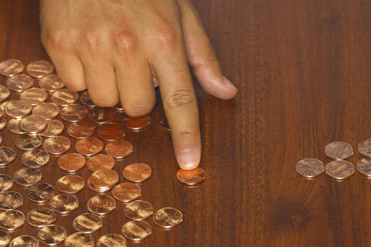 Homem conta moedas de centavos: embora a maior parte dos EUA e do mundo esteja economizando tão pouco, existem supereconomizadores (Burke/Triolo Productions/Thinkstock)