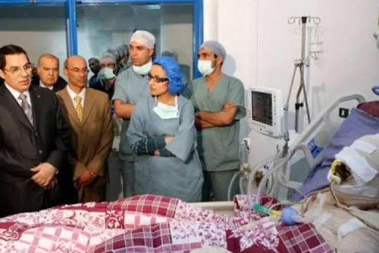 O então ditador tunisiano Ben Ali visita Mohammed Buazizi no hospital: regime cairia pouco tempo depois (AFP/Arquivo / Tunisia Presidency)