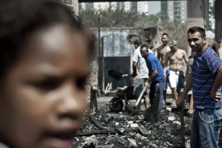 
	Moradores e vizinhos limpam terreno incendiado na favela do Moinho, em 2012
 (Marcelo Camargo/ABr)