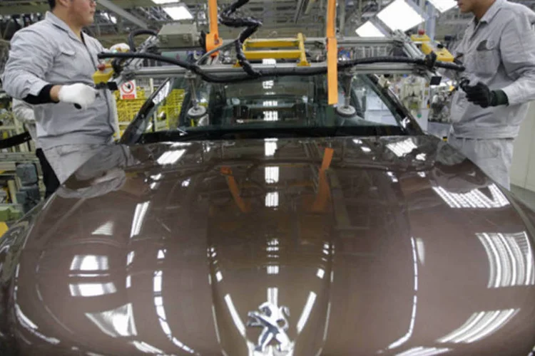 
	Trabalhadores na linha produ&ccedil;&atilde;o de um modelo da Peugeot
 (Reuters)