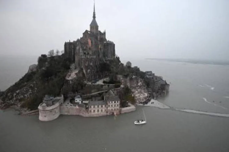 
	Imagem a&eacute;rea do Monte Saint-Michel com passarela encoberta pelas &aacute;guas esta manh&atilde;: fen&ocirc;meno influencia nas correntes mar&iacute;timas
 (DAMIEN MEYER/AFP)