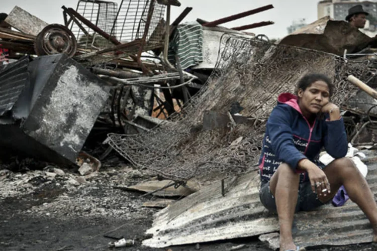 Moradora sentada em destroços após incêndio na favela Fazendinha: a prefeitura informou que tem dado toda a assistência às famílias prejudicadas (Marcelo Camargo/ABr)