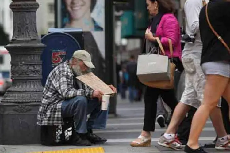 
	Pessoas passam por morador de rua em San Francisco: taxa de pobreza nos EUA era de 15% no ano passado e contrasta com a maior baixa em 26 anos, de 11,3%, em 2000
 (Justin Sullivan/Getty Images)