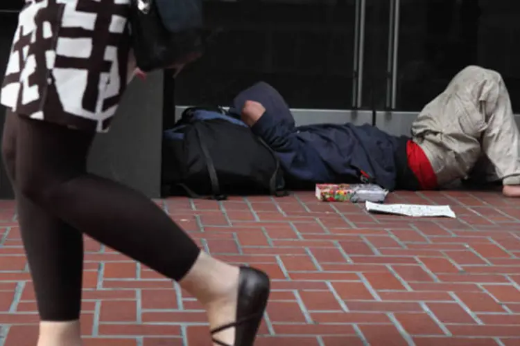 
	Mulher passa por morador de rua em San Francisco, Estados Unidos: cerca de 15% dos norte-americanos vivem na pobreza
 (Justin Sullivan/Getty Images)