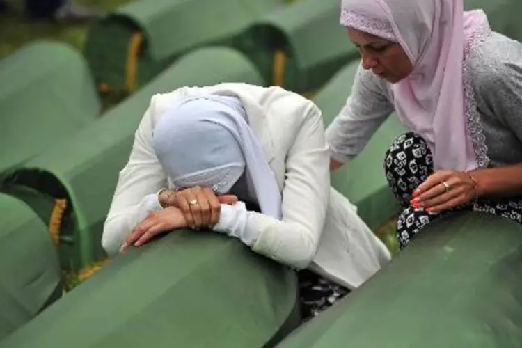 
	Mu&ccedil;ulmanas b&oacute;snias choram sobre os caix&otilde;es de parentes mortos no massacre de 1995 em Srebrenica
 (Elvis Barukcic/AFP)
