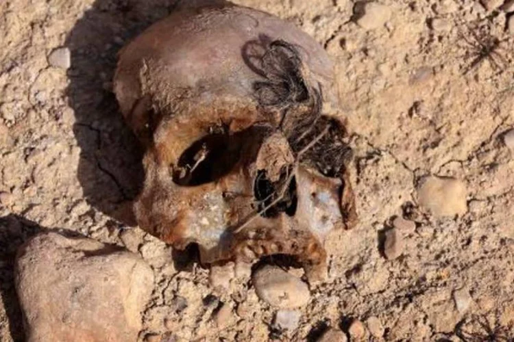 Vala comum contendo restos de membros da comunidade Yazidi é descoberta por forças curdas perto do vilarejo iraquiano de Sinuni (Safin Hamed/AFP)