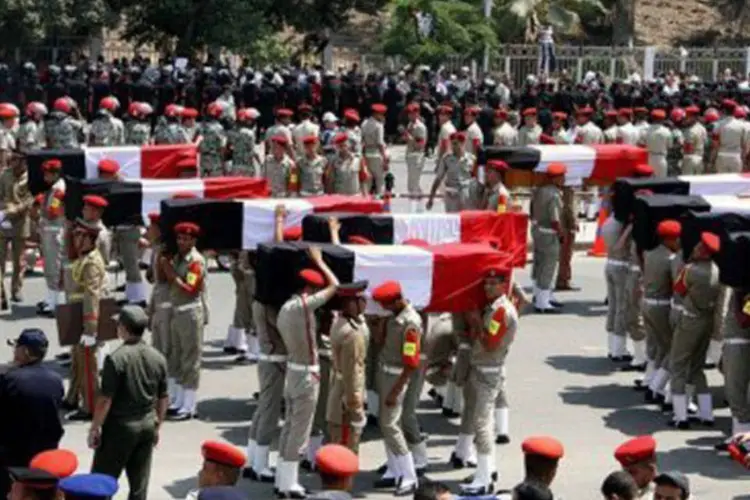 Policiais carregam caixões de 16 soldados mortos em ataque no Sinai: três dias depois do ocorrido, exército egípcio mata 20 ativistas em ação com helicópteros (Ahmed Mahmoud/AFP)