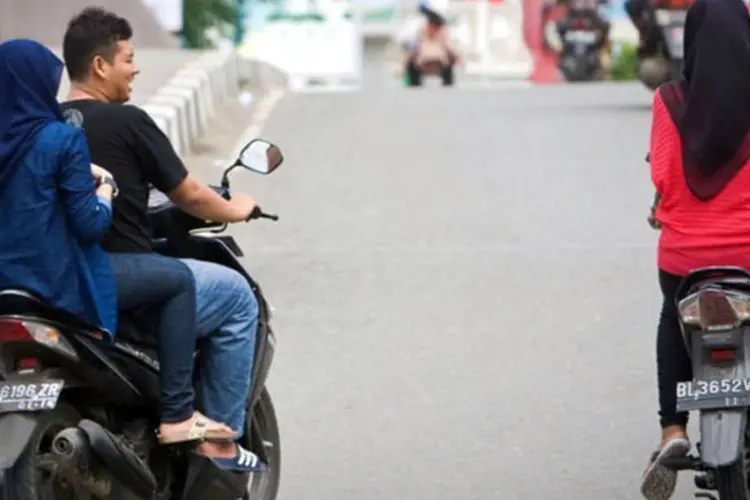 Mulheres andam de moto na Indonésia: o prefeito explicou que as mulheres que se sentam com as pernas separadas podem "provocar o motorista"
 (Chaideer Mahyuddin/AFP)