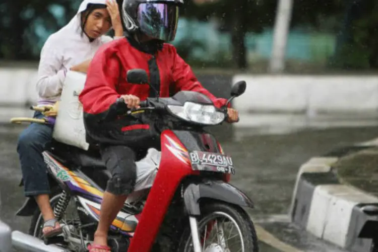 Mulher anda em uma motocicleta em Aceh, na Indonésia: a partir de agora as mulheres deverão se deslocar com as pernas juntas em um dos dois lados do veículo (Chaideer Mahyuddin/AFP)