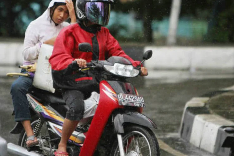 Mulher anda em uma motocicleta em Aceh, na Indonésia: a partir de agora as mulheres deverão se deslocar com as pernas juntas em um dos dois lados do veículo (Chaideer Mahyuddin/AFP)